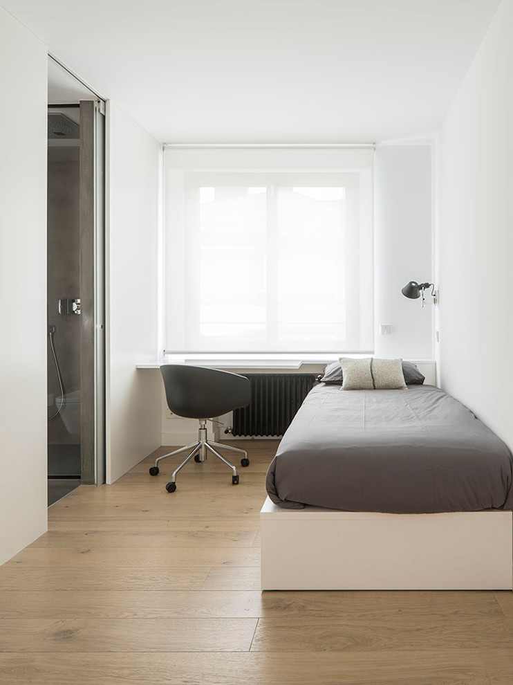 Modelo de habitación de invitados actual pequeña sin chimenea con paredes blancas y suelo de madera en tonos medios
