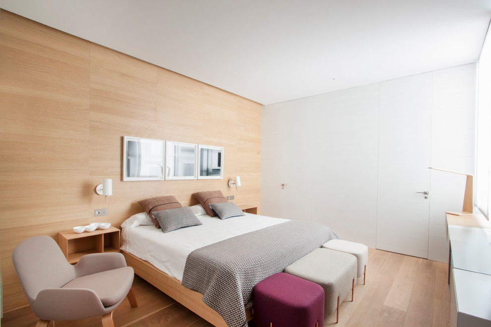 Mittelgroßes Skandinavisches Hauptschlafzimmer ohne Kamin mit beiger Wandfarbe und hellem Holzboden in Madrid