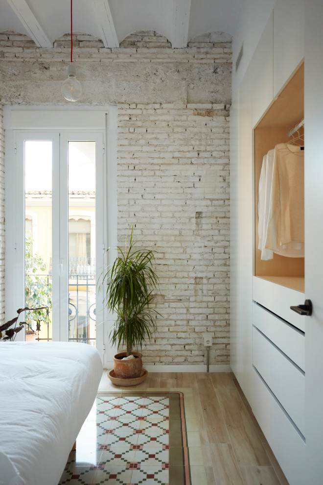 Стильный дизайн: спальня в современном стиле с белыми стенами, светлым паркетным полом, бежевым полом и кирпичными стенами - последний тренд
