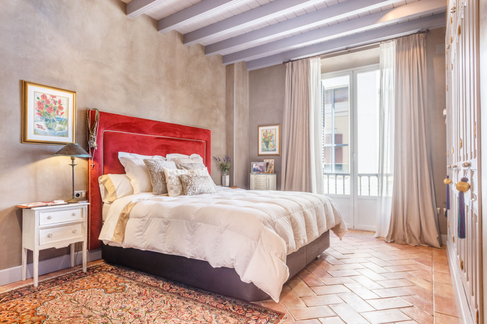 На фото: спальня в средиземноморском стиле с серыми стенами, полом из терракотовой плитки, красным полом, балками на потолке и потолком из вагонки с
