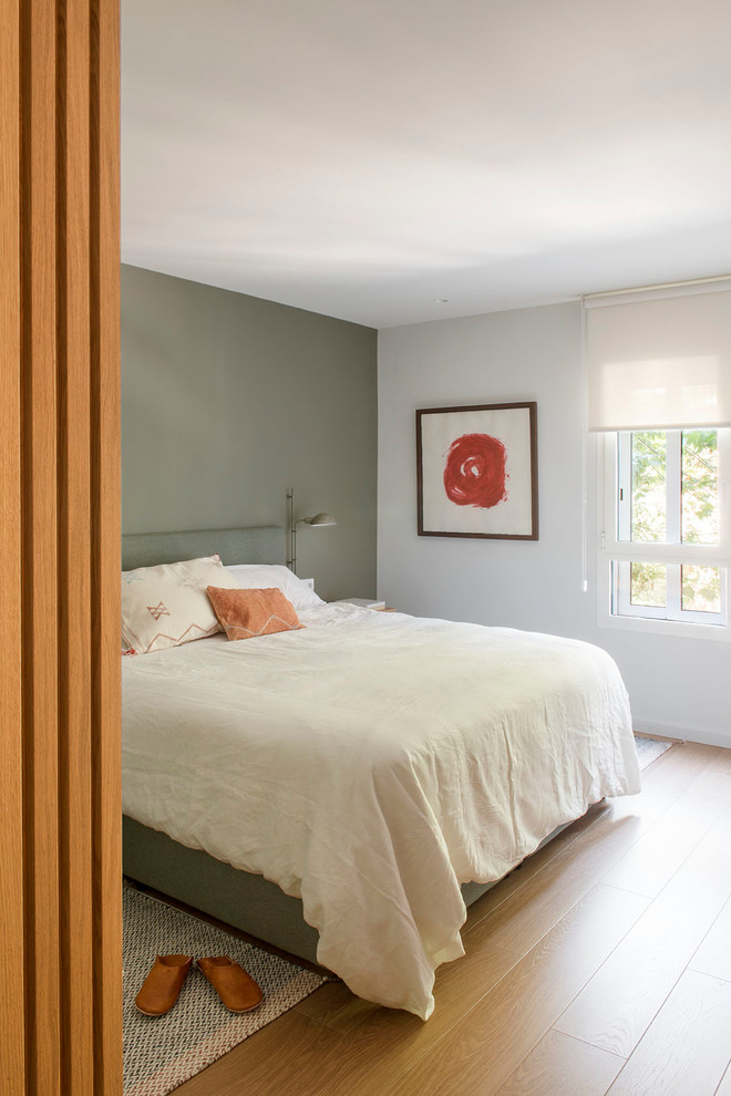 Идея дизайна: спальня в скандинавском стиле с зелеными стенами и коричневым полом