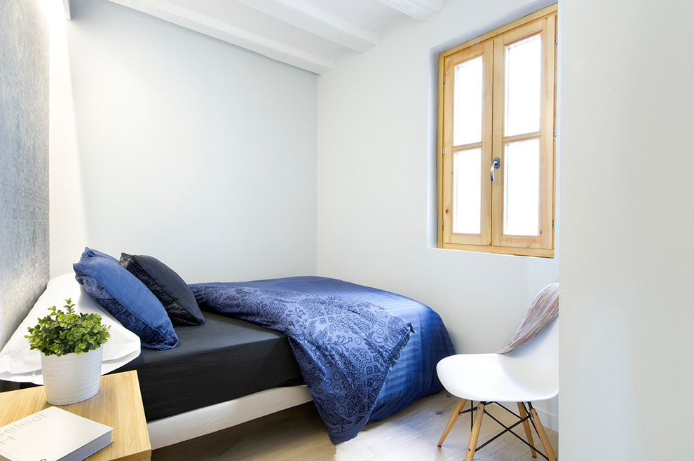 Imagen de dormitorio principal mediterráneo pequeño sin chimenea con suelo de madera en tonos medios