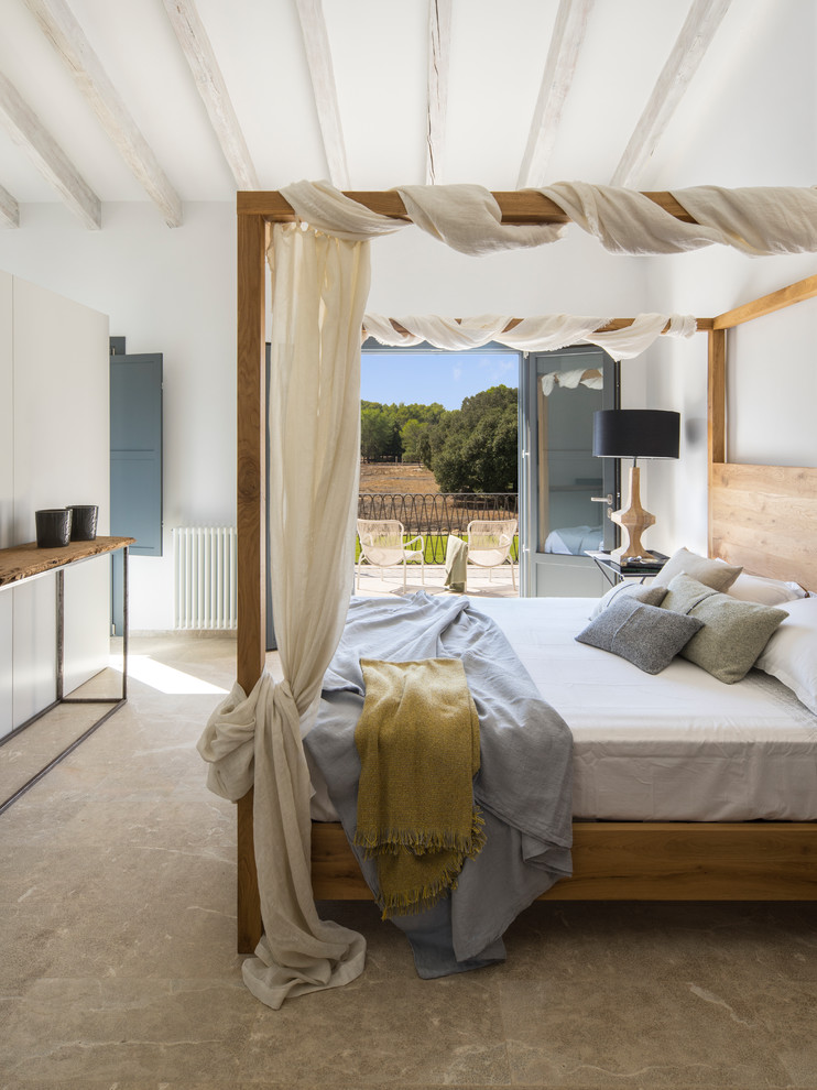 Réalisation d'une chambre parentale méditerranéenne avec un mur blanc, aucune cheminée et un sol marron.