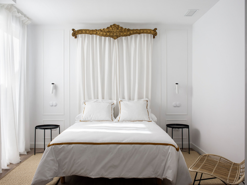 Imagen de dormitorio mediterráneo grande con paredes blancas, suelo de mármol, suelo blanco y boiserie