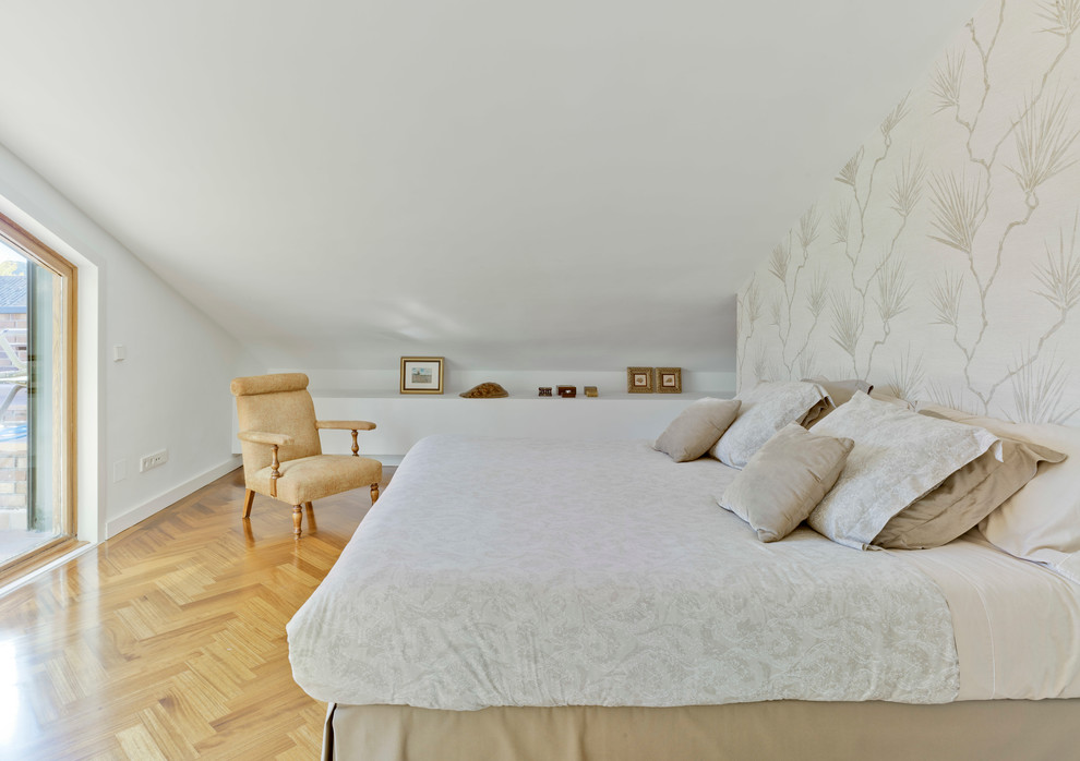 Modelo de dormitorio principal escandinavo grande sin chimenea con paredes blancas y suelo de madera en tonos medios