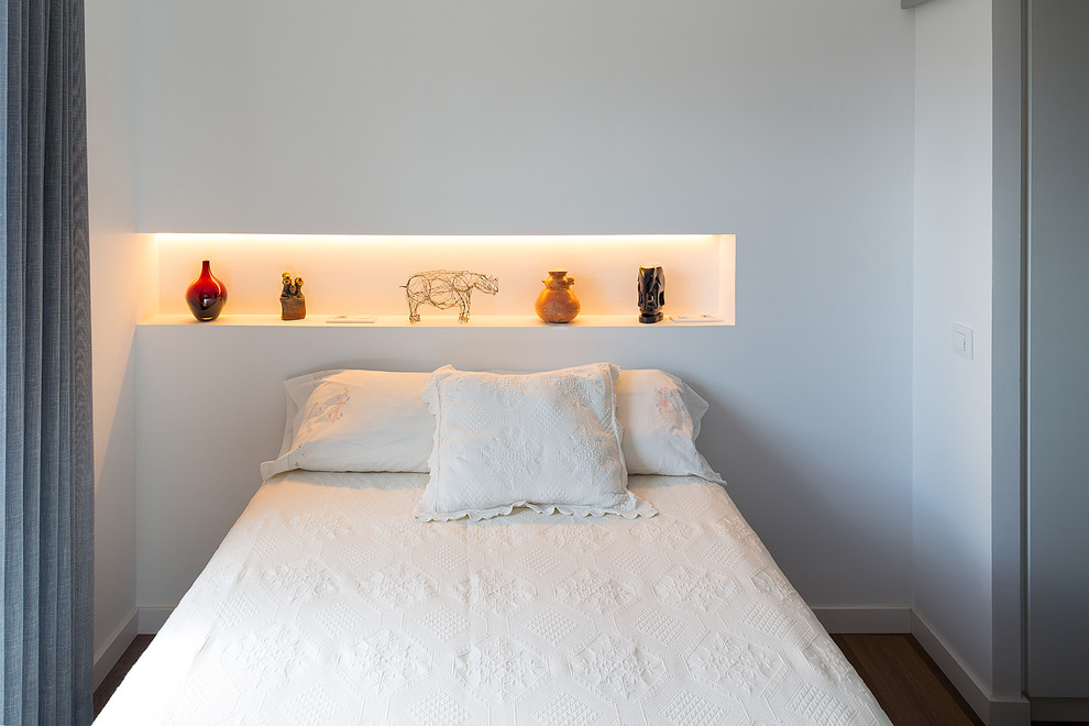 Foto de dormitorio principal actual de tamaño medio con paredes blancas, suelo de madera en tonos medios y suelo marrón
