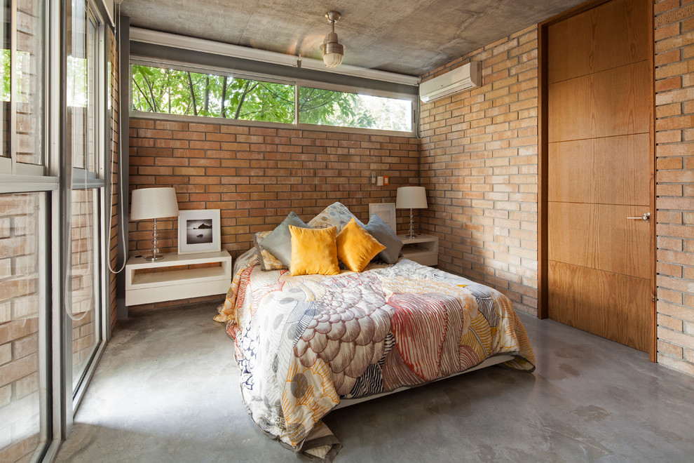 Ejemplo de dormitorio principal urbano de tamaño medio sin chimenea con paredes beige y suelo de cemento