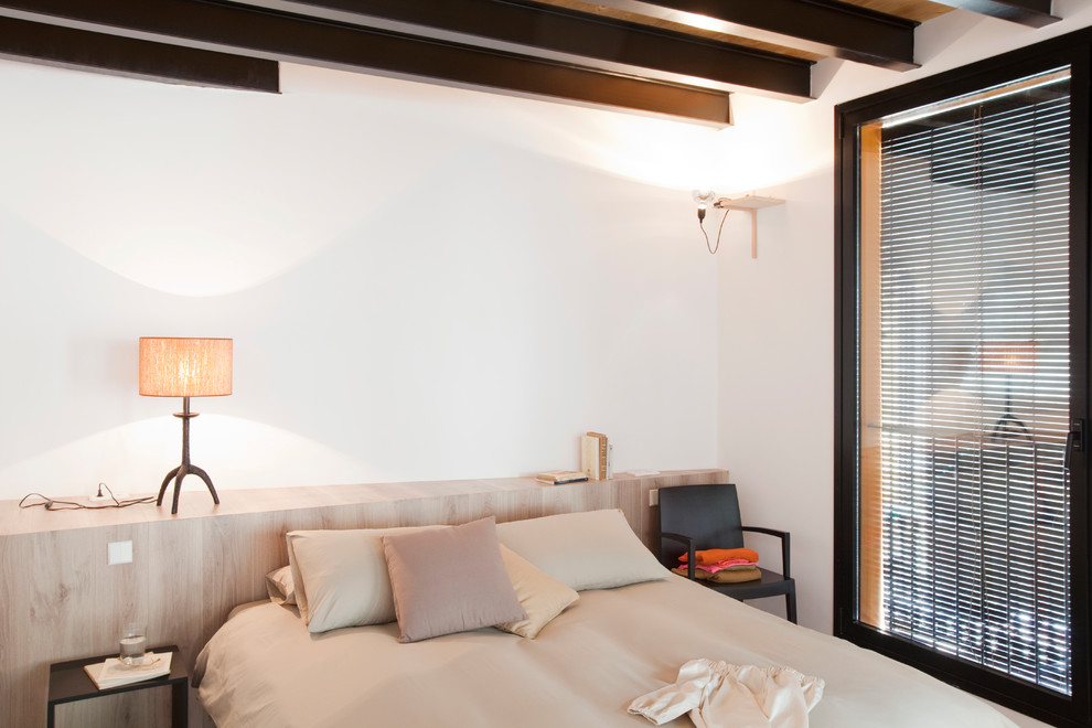 Imagen de dormitorio principal mediterráneo grande con paredes blancas y suelo de madera en tonos medios