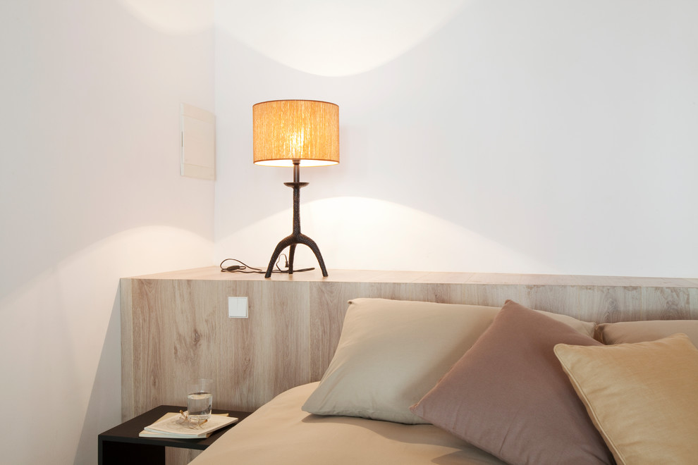 Imagen de dormitorio principal actual grande con paredes blancas y suelo de madera en tonos medios