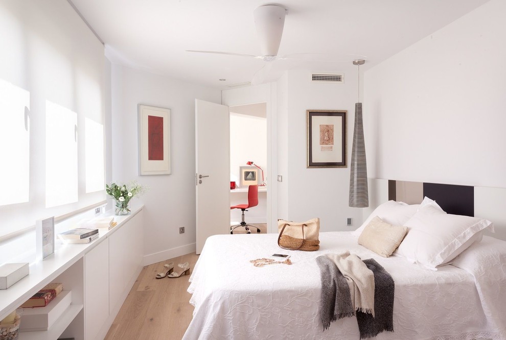 Modelo de dormitorio principal mediterráneo de tamaño medio sin chimenea con paredes blancas y suelo de madera en tonos medios