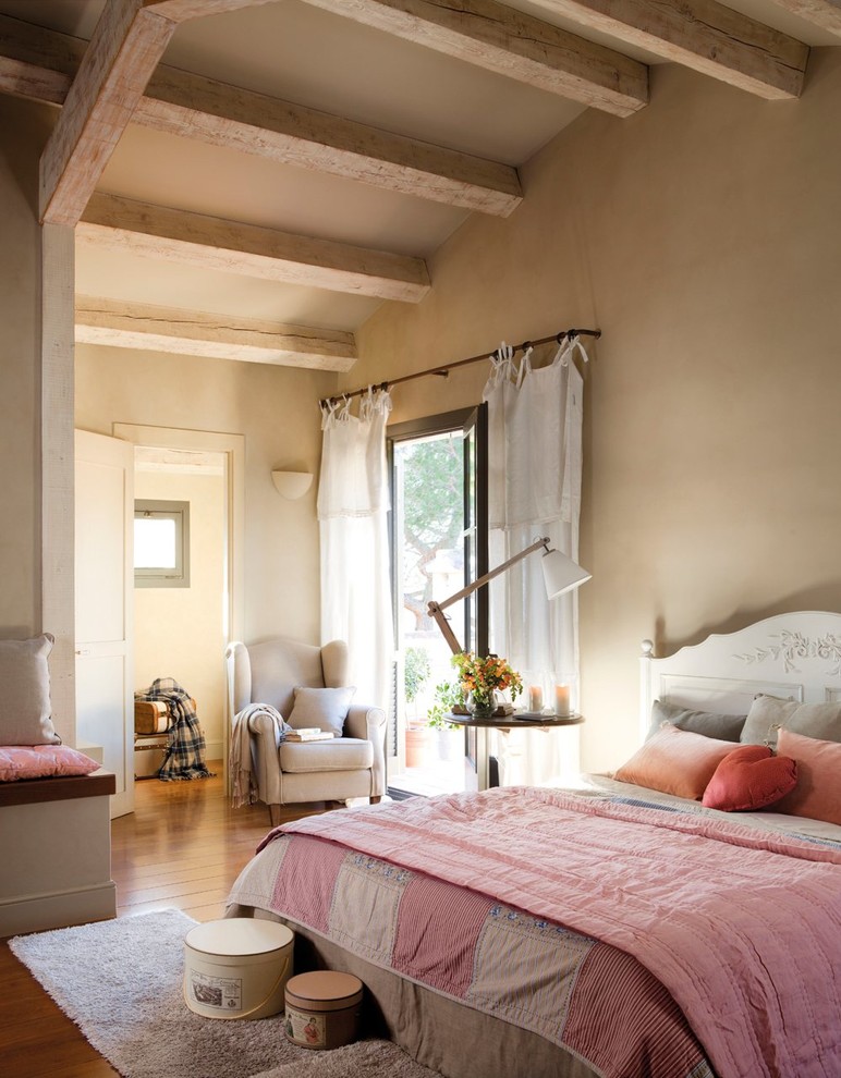 Imagen de dormitorio principal campestre de tamaño medio sin chimenea con paredes beige y suelo de madera en tonos medios