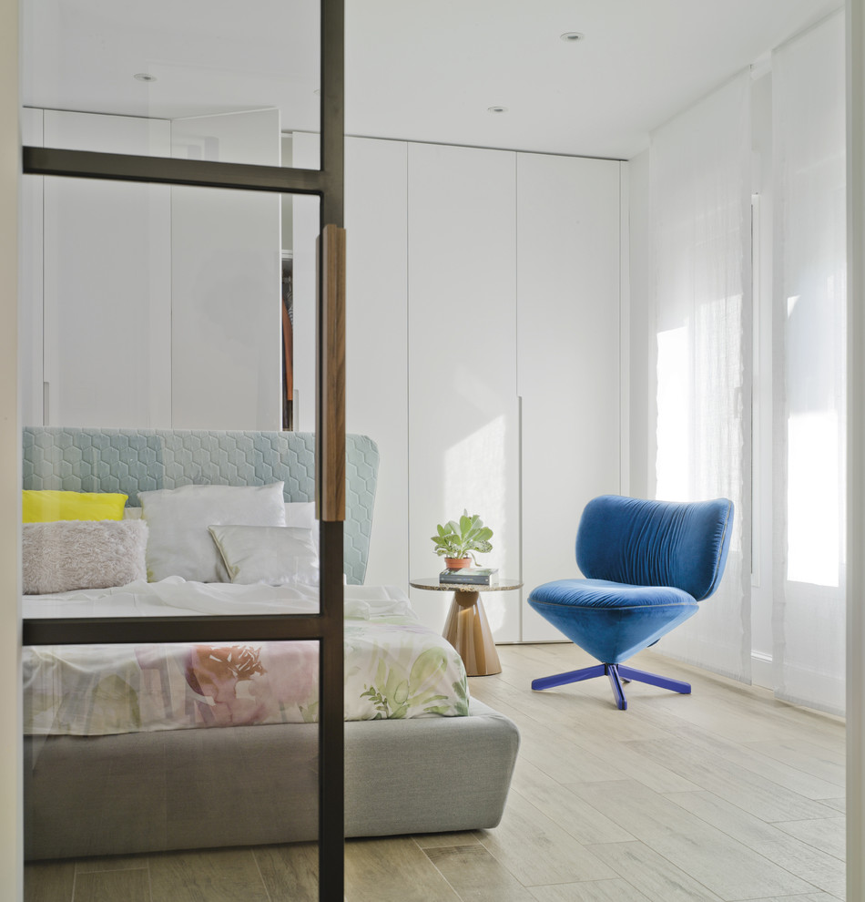 Cette image montre une chambre parentale design avec un mur blanc, parquet clair et un sol beige.