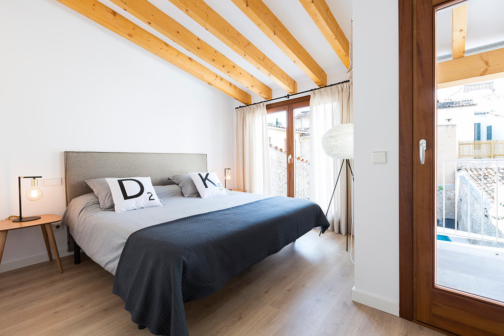 Cette photo montre une chambre parentale scandinave de taille moyenne avec un mur blanc, un sol en bois brun et aucune cheminée.