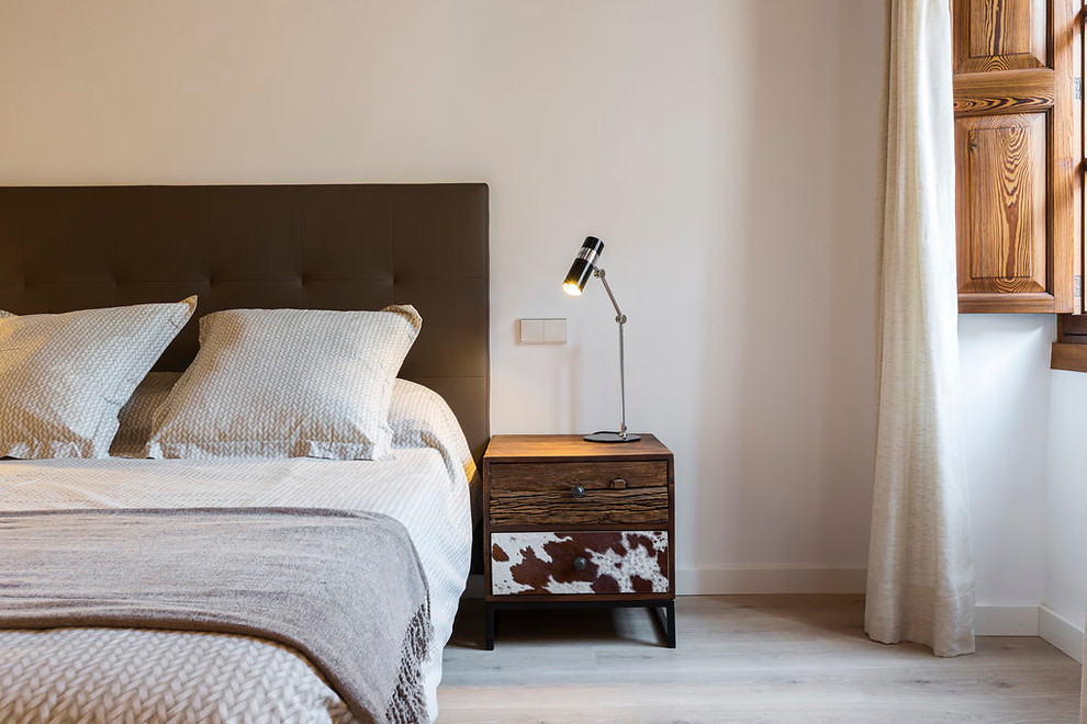 Imagen de dormitorio principal vintage de tamaño medio con paredes blancas y suelo de madera clara