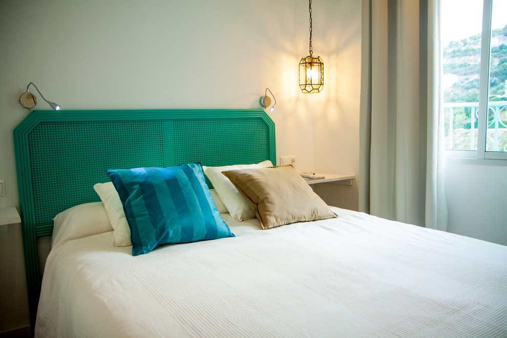 Ejemplo de dormitorio principal mediterráneo pequeño con paredes blancas, suelo de madera clara y suelo beige
