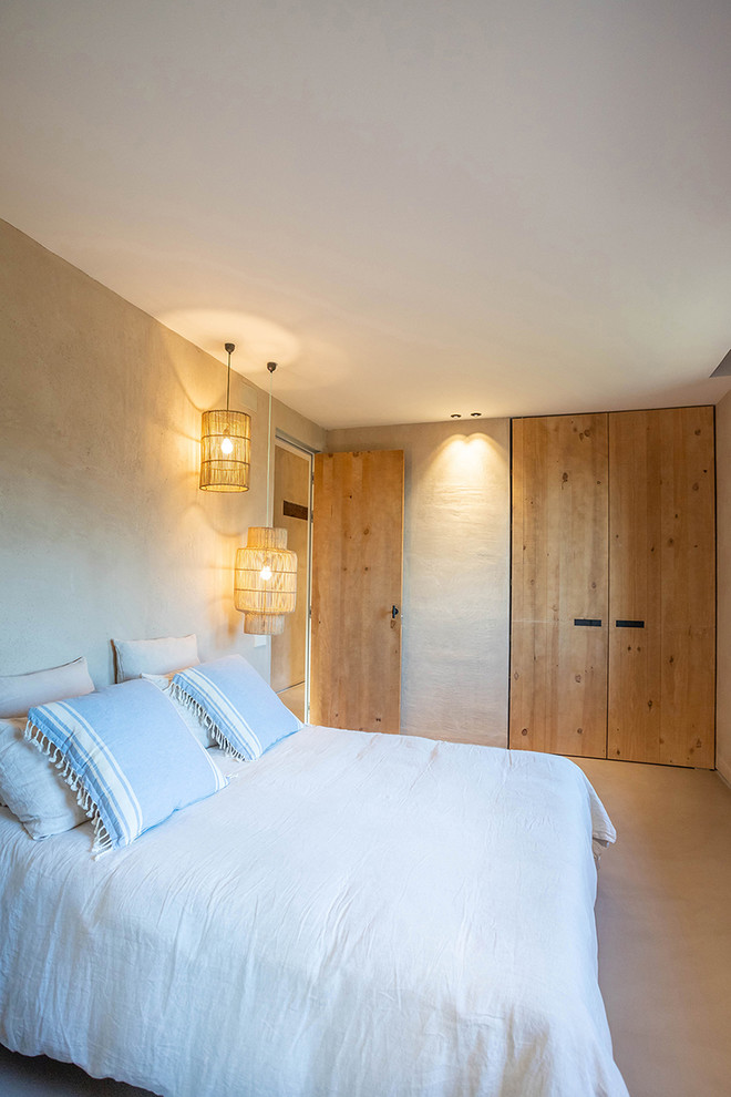 Esempio di una camera da letto mediterranea con pareti beige e pavimento beige
