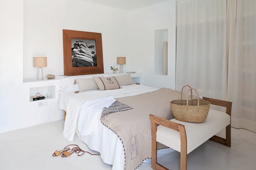 他の地域にある中くらいな地中海スタイルのおしゃれな主寝室 (白い壁、暖炉なし、コンクリートの床)