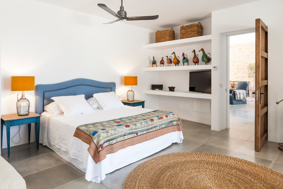 Diseño de dormitorio principal mediterráneo grande sin chimenea con paredes blancas, suelo de baldosas de cerámica y suelo gris