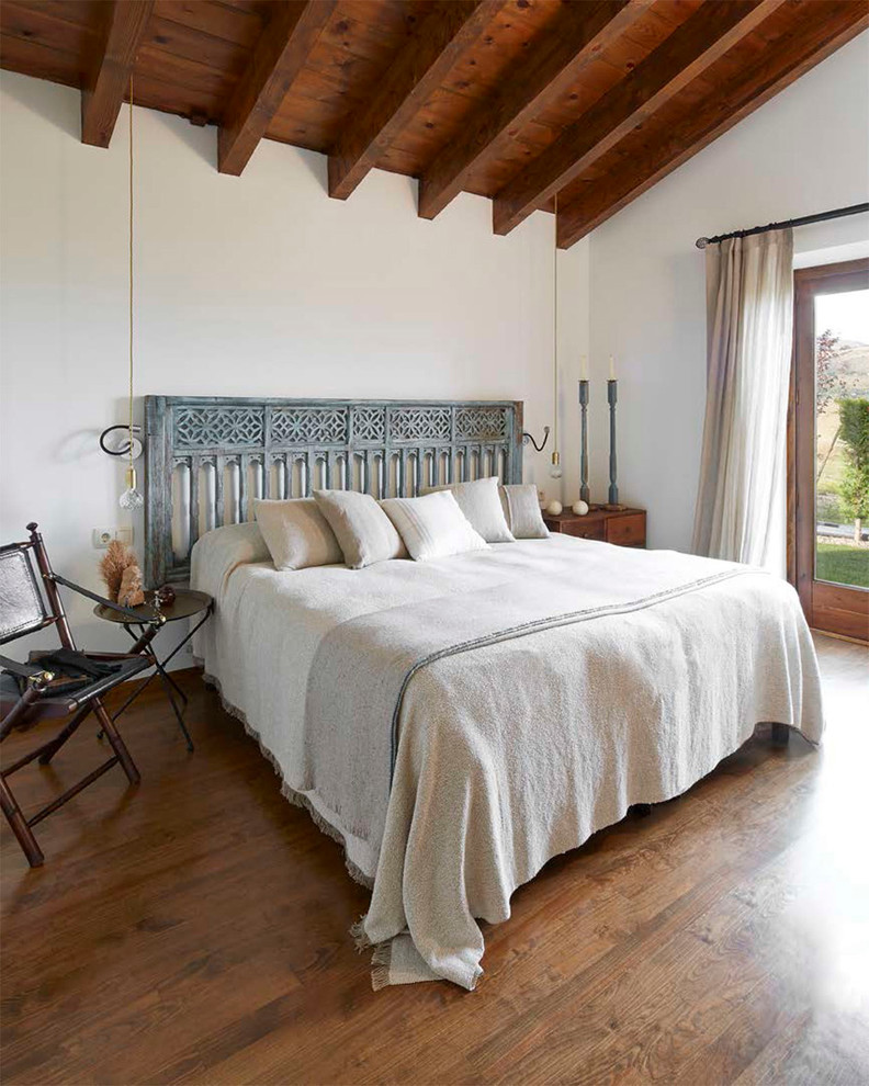 Foto de dormitorio principal campestre de tamaño medio sin chimenea con paredes blancas y suelo de madera oscura