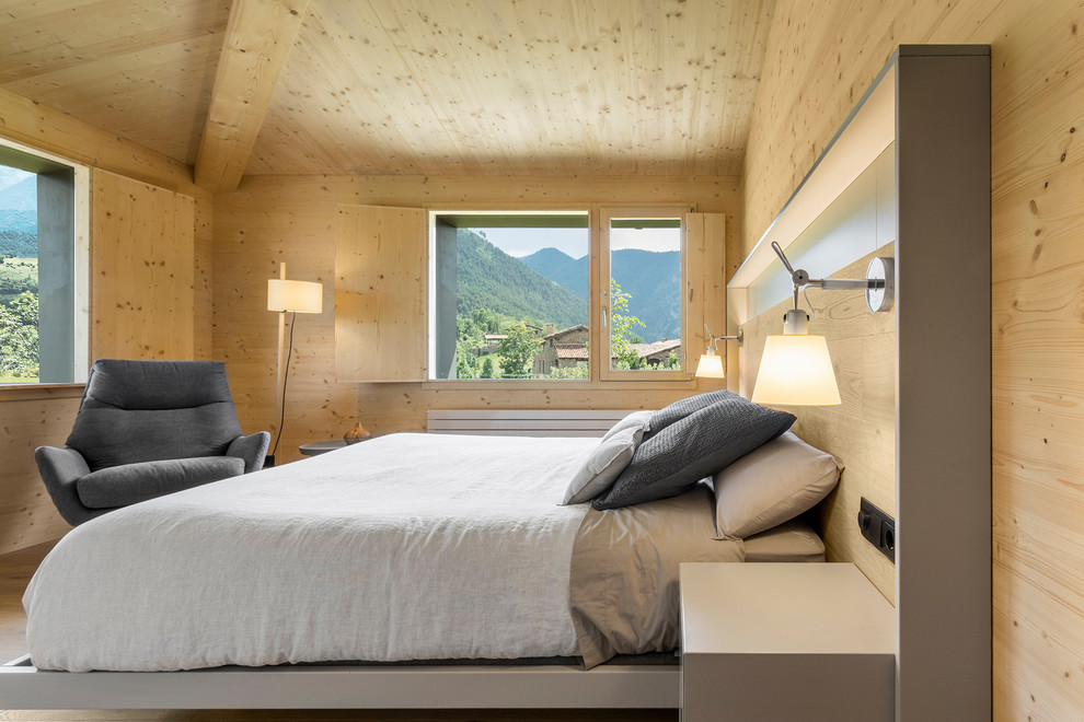 На фото: спальня в стиле модернизм с светлым паркетным полом без камина с