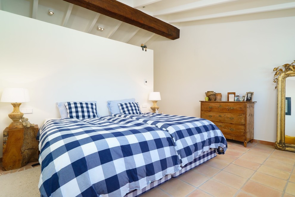 Foto de dormitorio principal mediterráneo con paredes blancas, suelo de baldosas de terracota y suelo beige