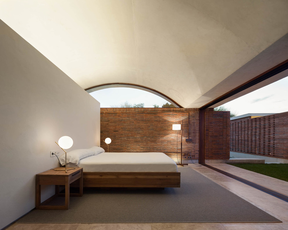 Inspiration för ett mellanstort funkis huvudsovrum, med travertin golv och beige väggar