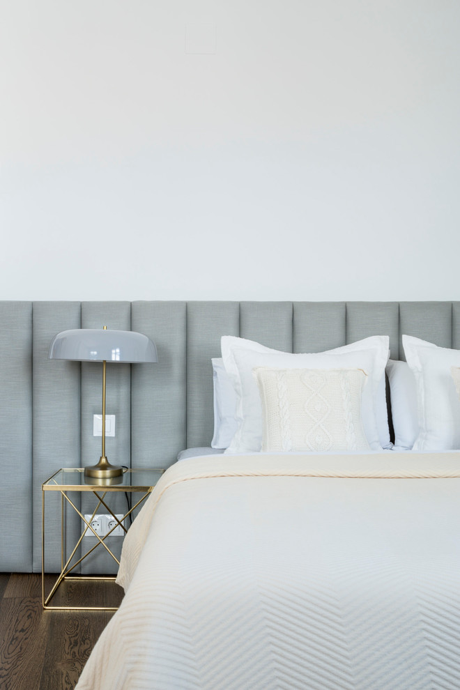 Imagen de habitación de invitados actual grande con paredes blancas y suelo de madera en tonos medios