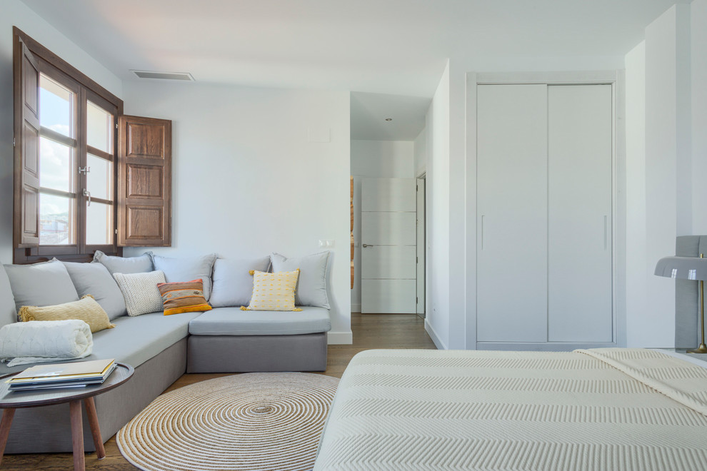 Idee per una grande camera degli ospiti minimal con pareti bianche, pavimento in legno massello medio e pavimento marrone