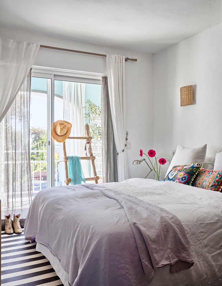 Imagen de dormitorio principal mediterráneo de tamaño medio sin chimenea con paredes blancas