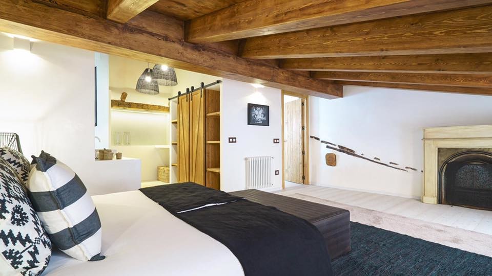 バレンシアにある中くらいな地中海スタイルのおしゃれな寝室 (白い壁、淡色無垢フローリング、標準型暖炉、石材の暖炉まわり、白い床) のレイアウト