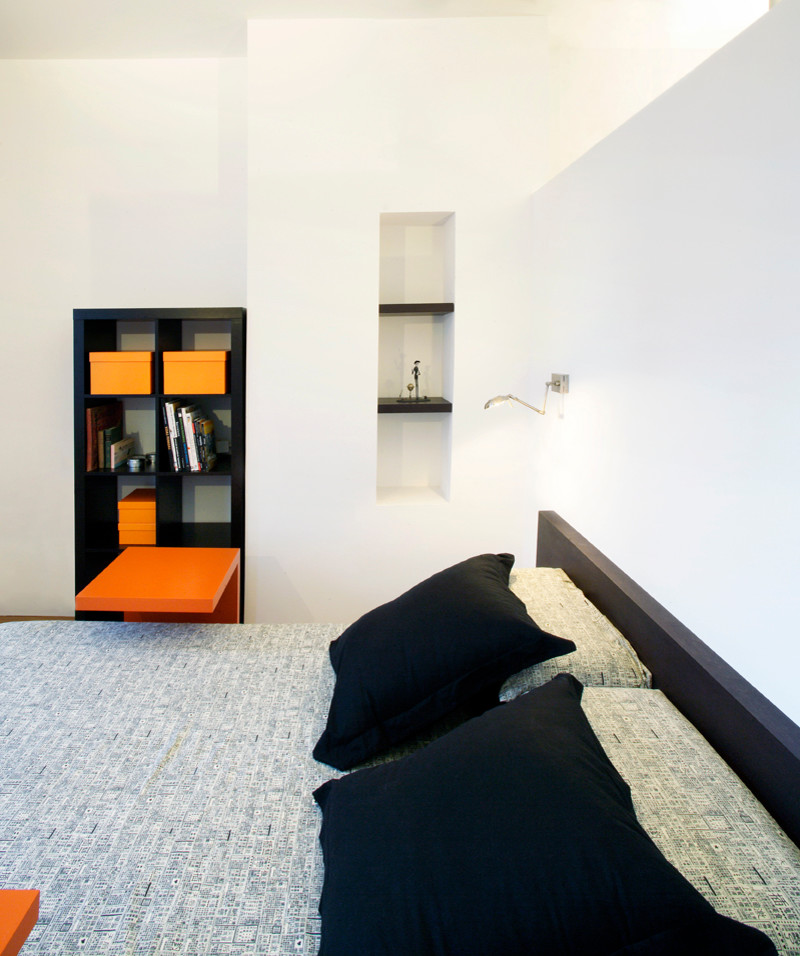Ejemplo de dormitorio principal actual de tamaño medio sin chimenea con paredes blancas