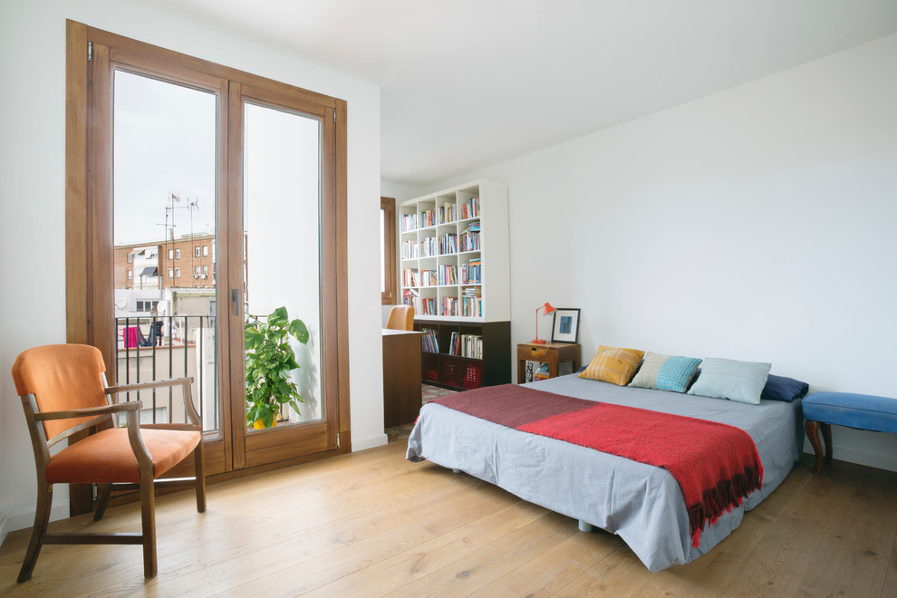 Imagen de dormitorio principal actual grande sin chimenea con paredes blancas, suelo de madera en tonos medios y con escritorio