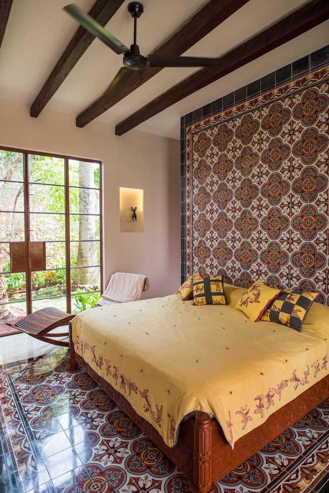 Immagine di una camera da letto american style con pareti beige e pavimento multicolore