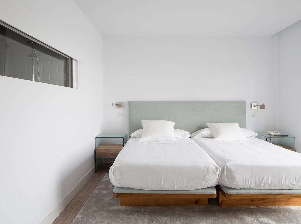 Foto de habitación de invitados moderna con paredes blancas y suelo beige