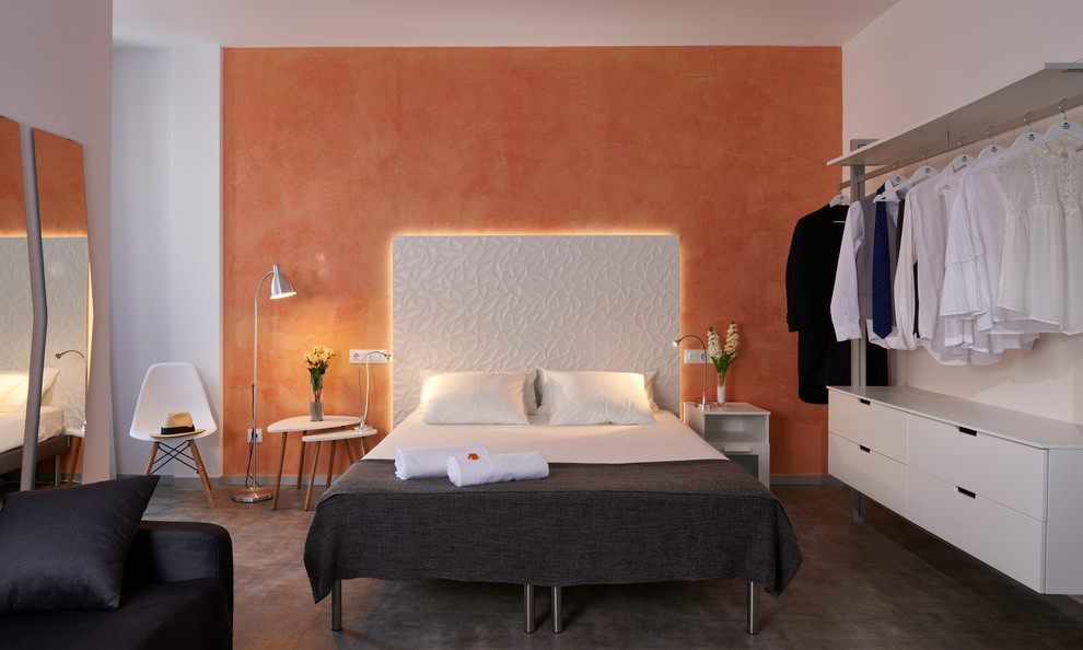 Cette photo montre une chambre tendance avec un mur orange et un sol gris.