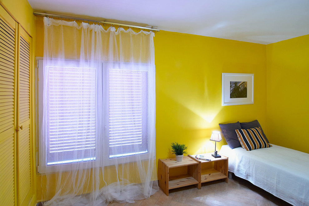 Idée de décoration pour une petite chambre d'amis tradition avec un mur jaune, un sol en bois brun et aucune cheminée.