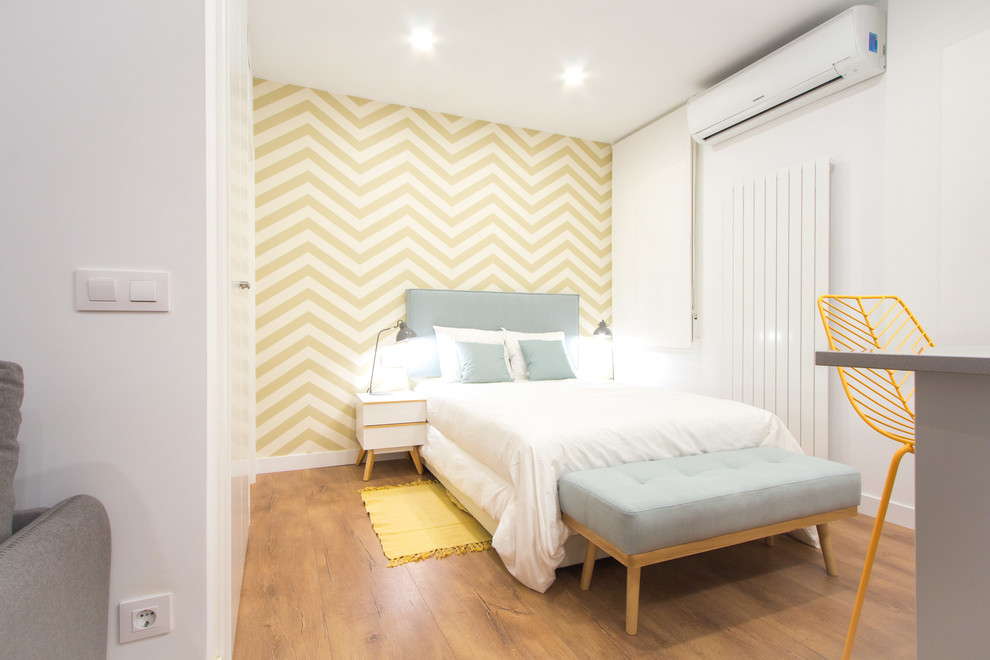 Ejemplo de dormitorio principal nórdico pequeño con suelo laminado y suelo marrón