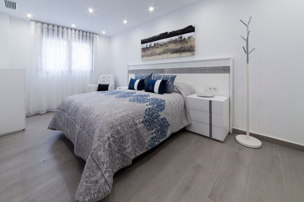 Esempio di una camera matrimoniale moderna di medie dimensioni con pareti bianche, pavimento in gres porcellanato e pavimento grigio