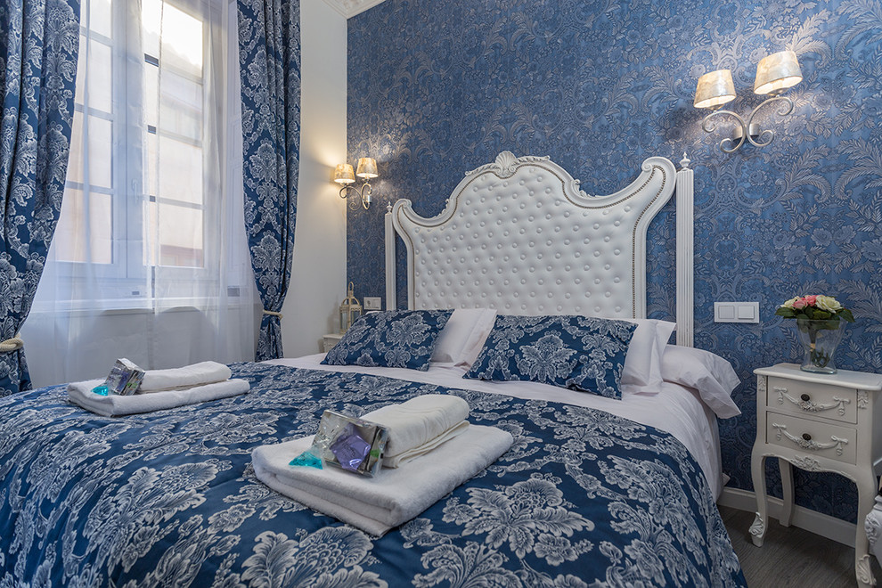 Mittelgroßes Shabby-Style Hauptschlafzimmer mit blauer Wandfarbe und braunem Holzboden in Madrid