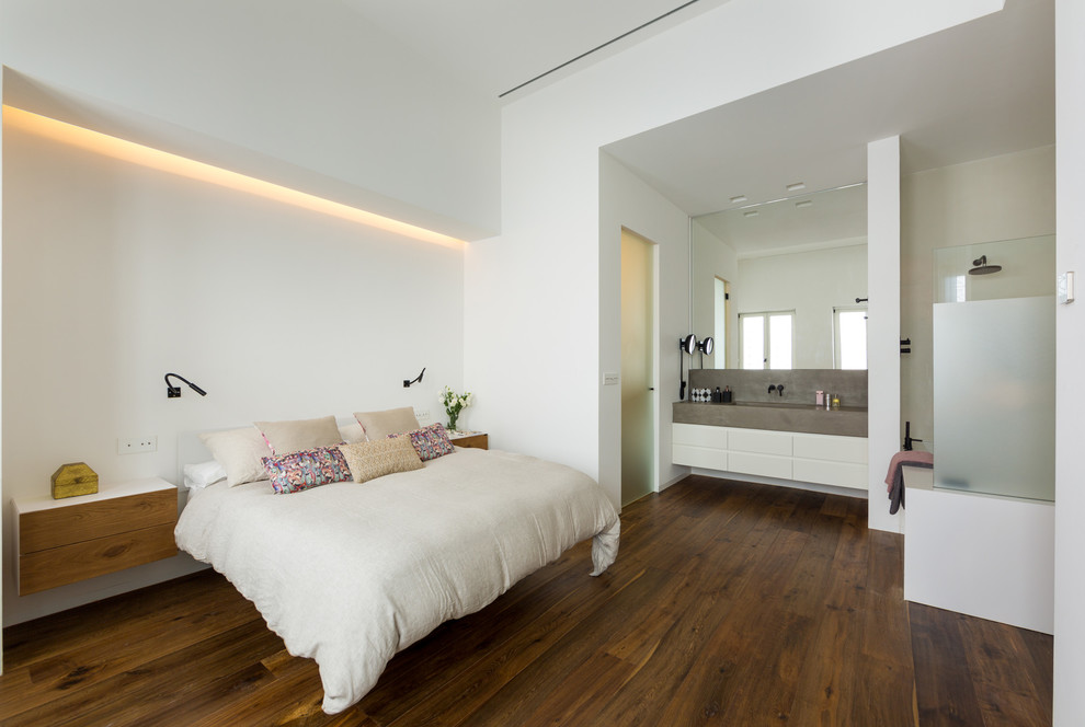 Modelo de dormitorio principal contemporáneo con paredes blancas, suelo marrón y suelo de madera en tonos medios