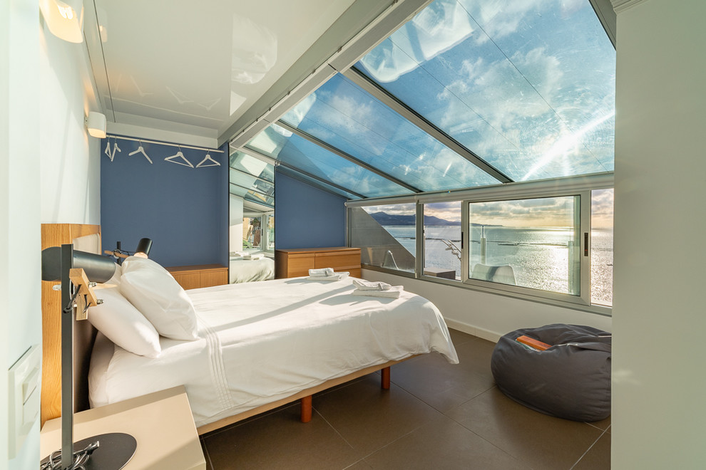 Diseño de dormitorio contemporáneo con suelo gris y paredes azules