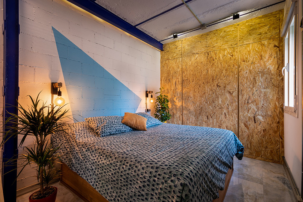 Diseño de dormitorio tipo loft minimalista con paredes azules, suelo de mármol y suelo gris