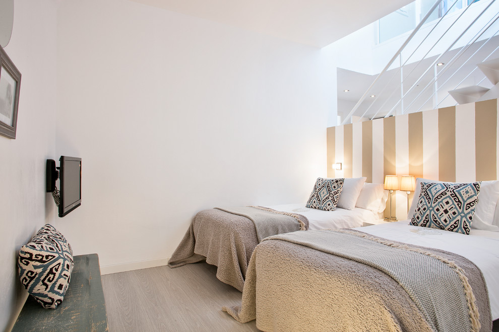バルセロナにある中くらいなトランジショナルスタイルのおしゃれな客用寝室 (白い壁、淡色無垢フローリング、暖炉なし) のレイアウト