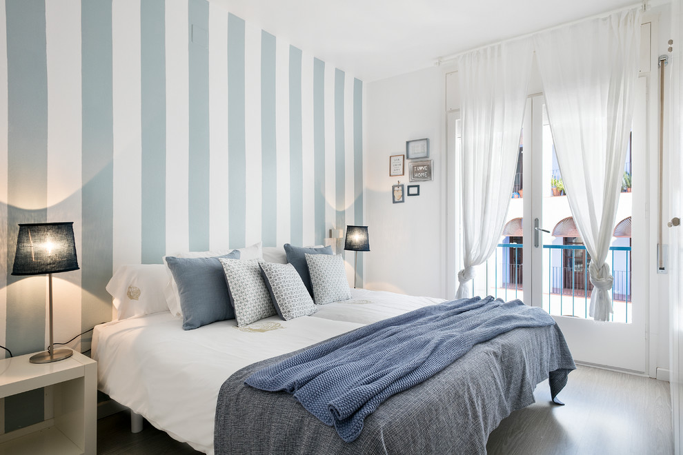 Ejemplo de dormitorio principal marinero de tamaño medio sin chimenea con paredes multicolor
