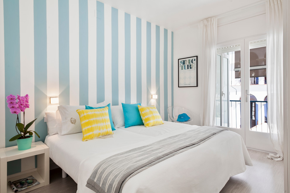 Modelo de dormitorio principal costero de tamaño medio sin chimenea con paredes azules y suelo de madera oscura