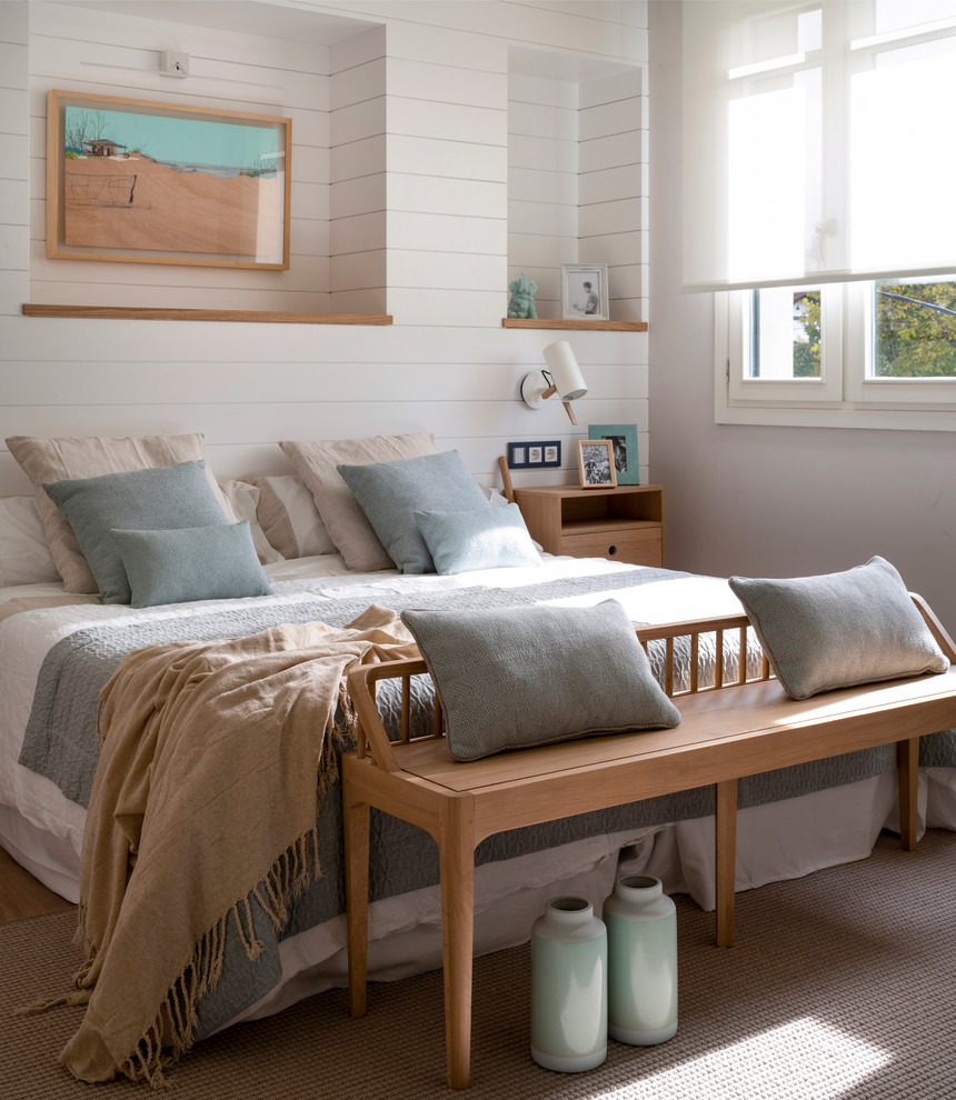 Modelo de dormitorio principal nórdico grande sin chimenea con suelo laminado, suelo marrón y paredes grises