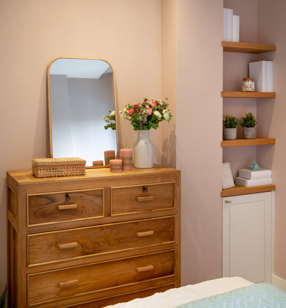 Diseño de habitación de invitados tradicional renovada pequeña sin chimenea con paredes rosas, suelo laminado, suelo marrón, bandeja y papel pintado