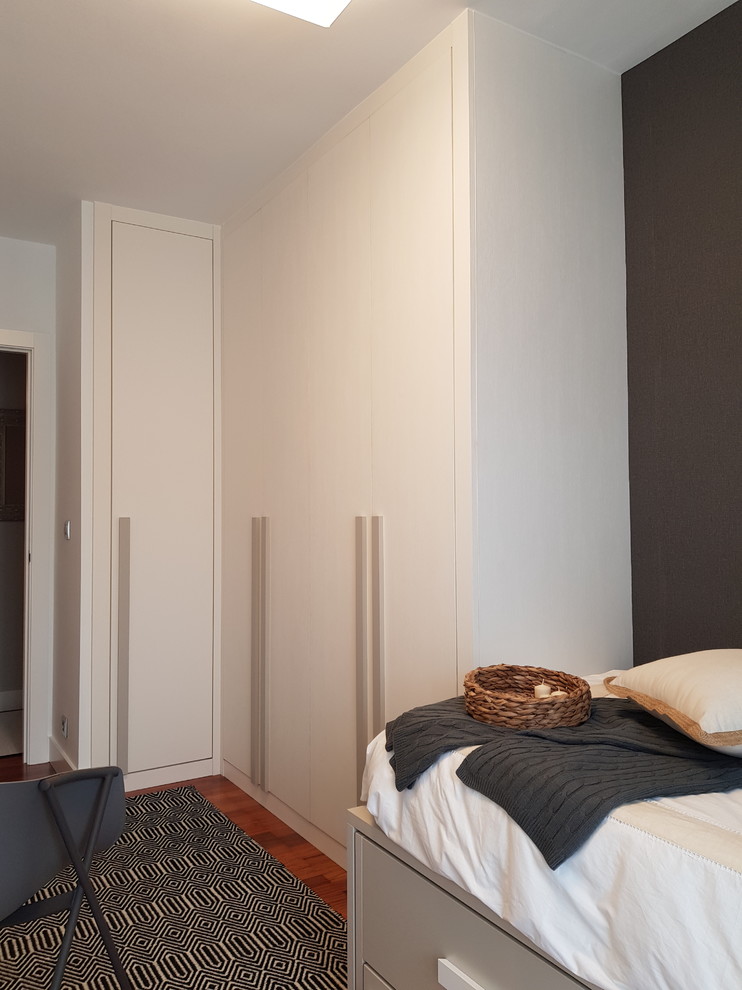 Foto de habitación de invitados escandinava pequeña con paredes blancas y suelo de madera en tonos medios