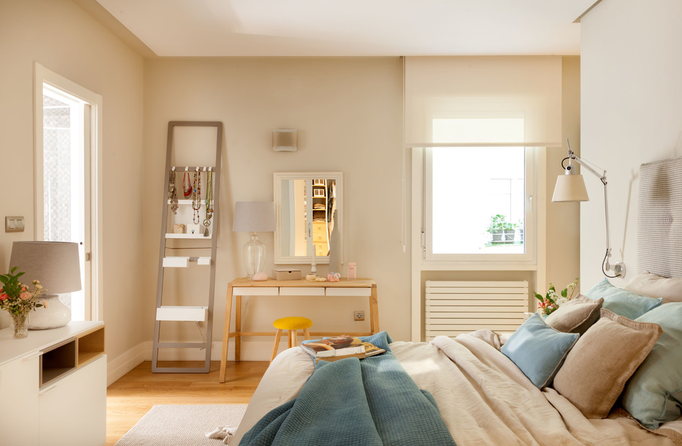 Ejemplo de dormitorio principal actual de tamaño medio con paredes beige, suelo de madera en tonos medios y suelo marrón