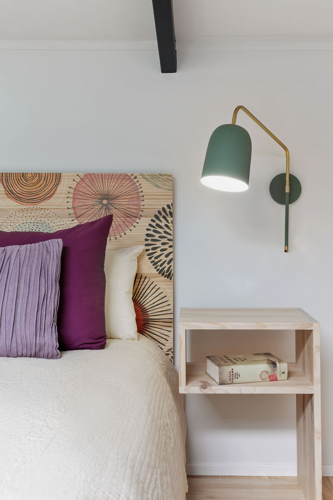 Ejemplo de dormitorio tipo loft escandinavo de tamaño medio con paredes blancas, suelo de madera clara y suelo beige